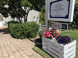 A sign for Chez Pierre, a guest house, with a contact number.