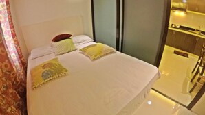 Une chambre d’hôtel avec un lit, une table de chevet, un miroir et une fenêtre.