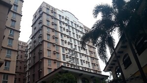 Un immeuble résidentiel à plusieurs étages, doté de balcons et de climatiseurs.