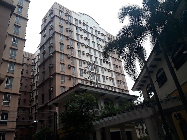 A multi-story residential building with balconies and air conditioning units.