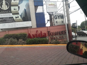 A building with a large sign for 'Avida Towers' and a 'GYM' sign.
