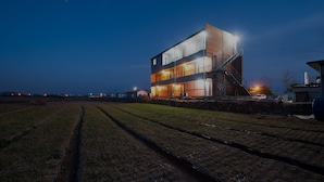 Un bâtiment moderne à deux étages, doté d’un toit plat et d’un escalier menant à l’étage supérieur.