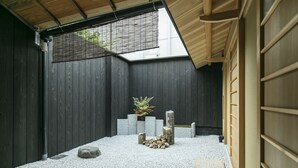 A traditional Japanese room with tatami flooring, a low wooden ceiling, and a shoji screen.
