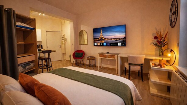 A hotel room with a bed, a desk, a chair, a TV, and a bookshelf. - Belterre Studio – Between Sky & Sea (Boulogne-sur-Mer)