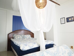 A bedroom with two beds, a wooden headboard, and a white canopy. - Holiday Homes TSUBOYA 2nd (Naha)