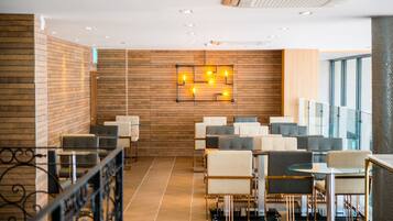 A modern indoor seating area with a wooden wall, a light fixture, and a glass railing.