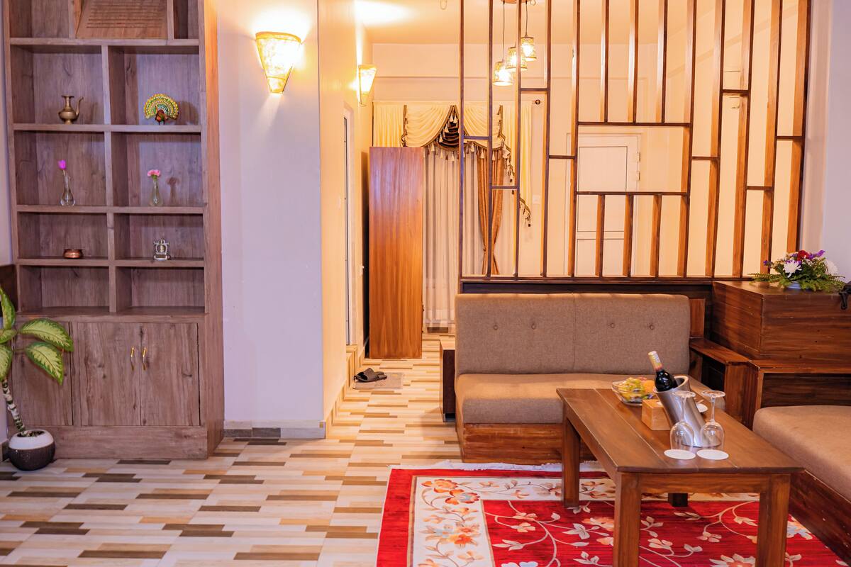A cozy living room with a sofa, wooden coffee table, and a bookshelf.