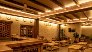 Un interior acogedor y rústico con muebles de madera, una zona de bar y un reloj en la pared.