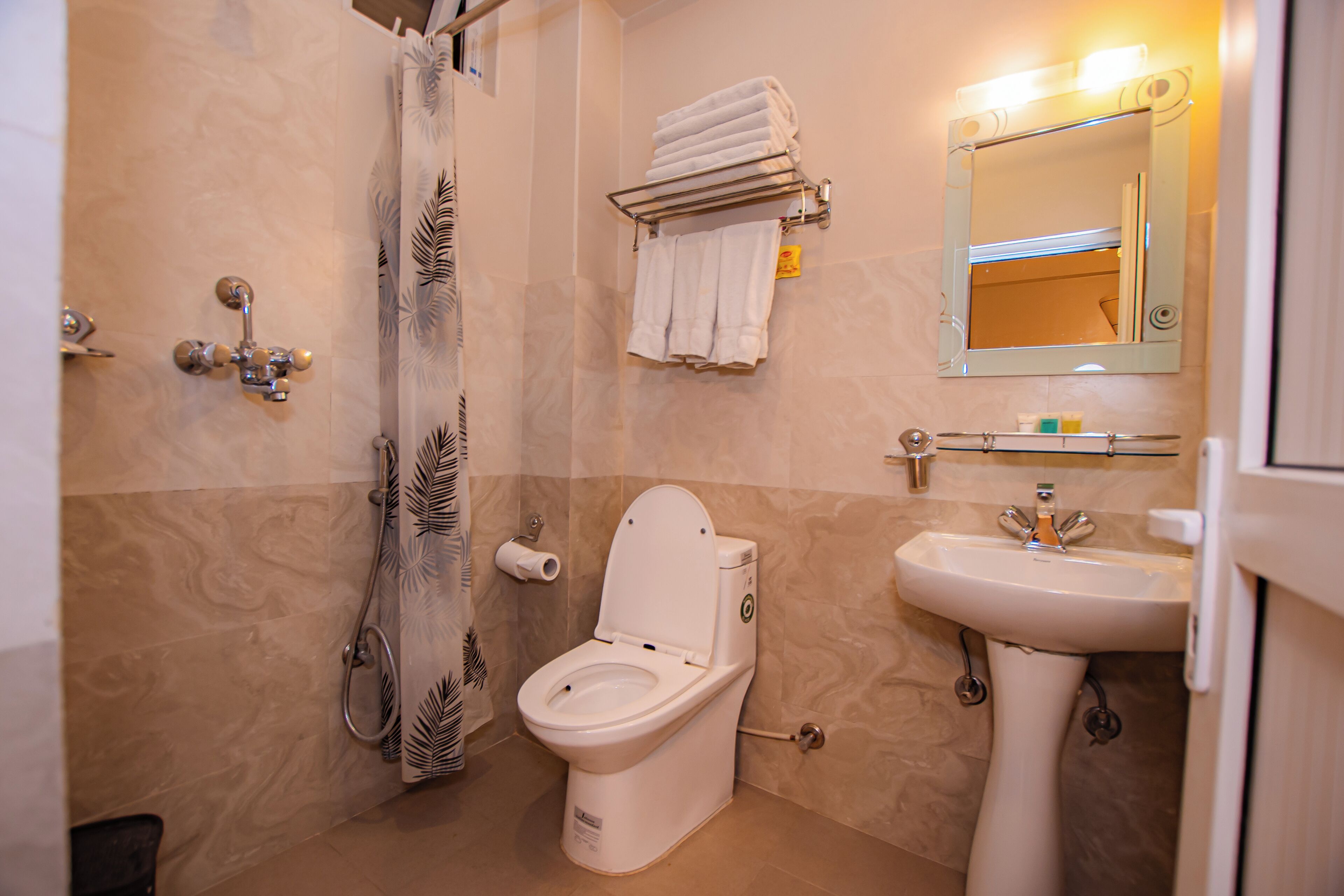 A bathroom with a toilet, sink, and shower curtain.