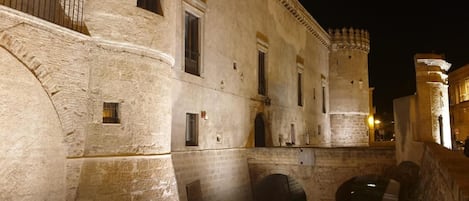 Un edificio histórico de piedra con arcos y un balcón.