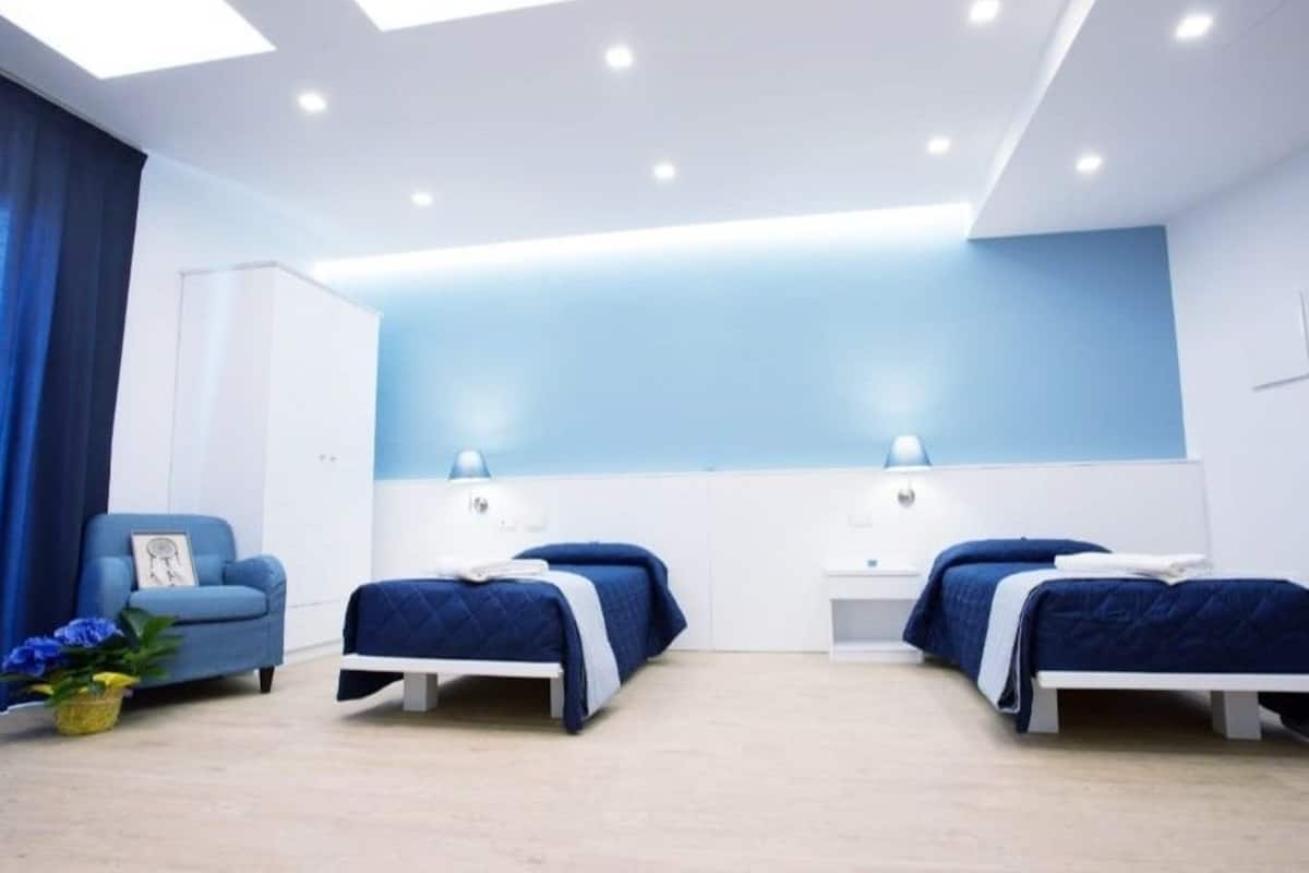 Un dormitorio moderno con dos camas, un escritorio y una silla.
