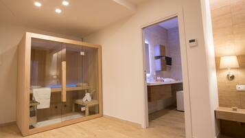 Bathroom features a glass-enclosed shower area with a bench and a sink with a mirror.