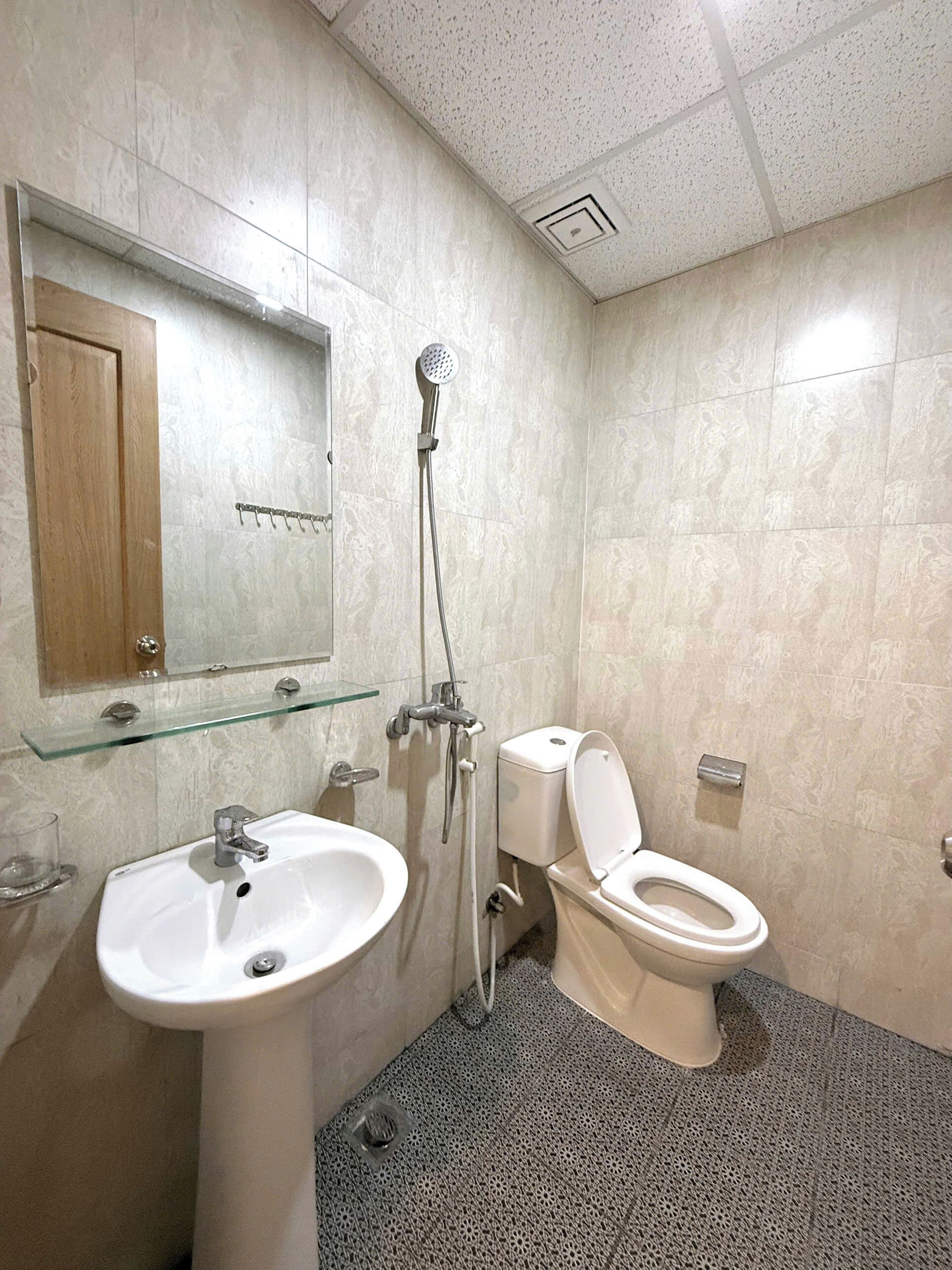 Un baño con inodoro, lavamanos y ducha.