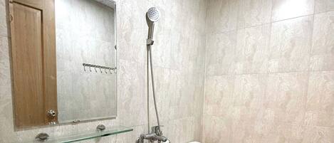 Un baño con inodoro, lavamanos y ducha.