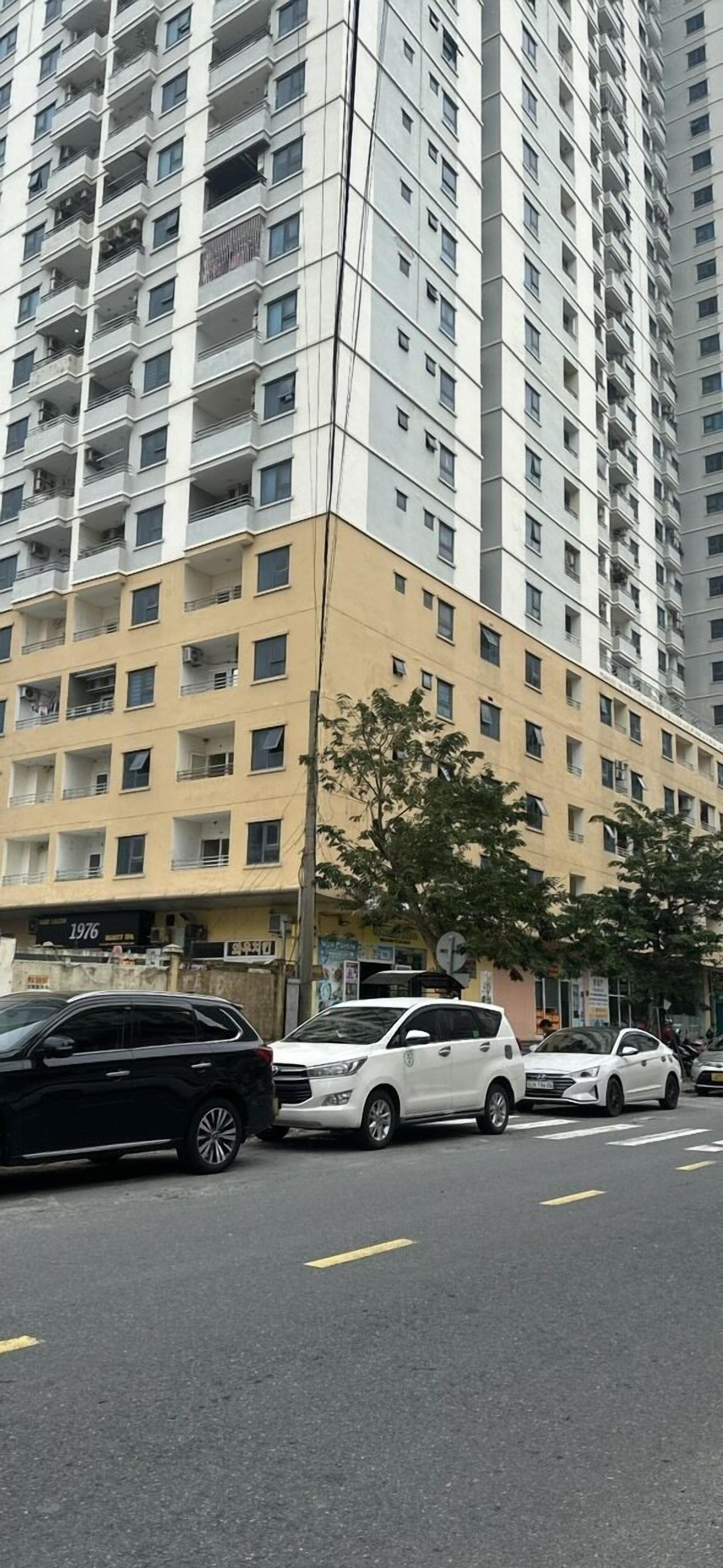 Un edificio de varios pisos con fachada color crema y numerosas ventanas.