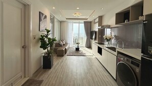 Eine moderne Küche mit Waschmaschine, einem Essbereich mit Sofa und einem großen Fenster.