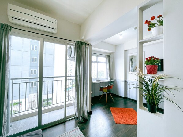 Un apartamento moderno con balcón, ventanas amplias y vistas a edificios.