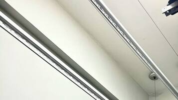 Eine Decke mit Schienenspots und einem Rauchmelder.