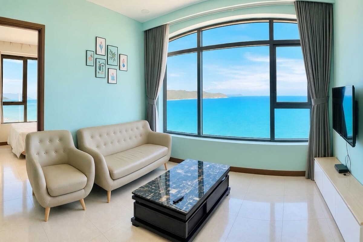 A modern living room with a sofa, armchairs, a coffee table, and a TV.