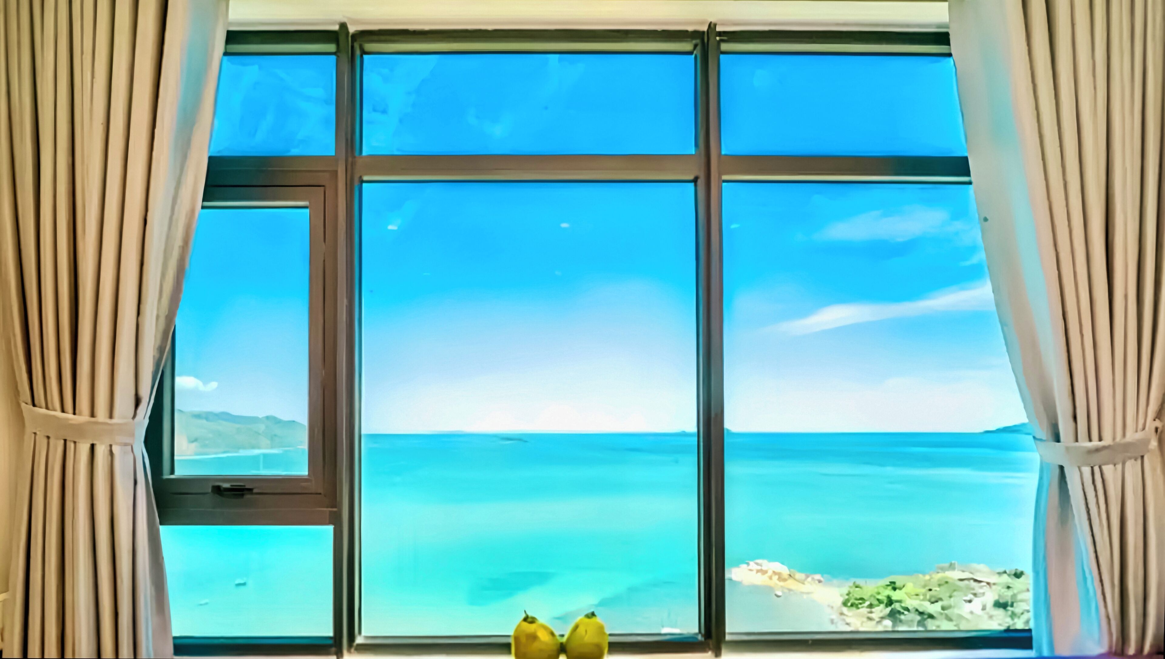 A window with curtains, a view of the sea, and two bananas on the windowsill.