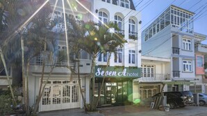 A hotel with a green sign, multiple floors, and a balcony. - Seven A Hotel (Xuan Huong - Da Lat)
