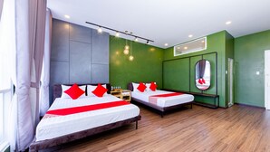 A hotel room with two beds, a mirror, a wooden floor, and a green accent wall. - Seven A Hotel (Xuan Huong - Da Lat)