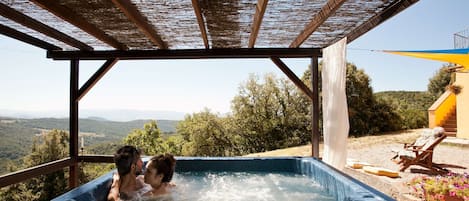 A hot tub with a view of the countryside.