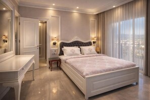 Un dormitorio con una cama grande, lámparas de noche, un aparador y vistas a la ciudad a través de amplias ventanas.