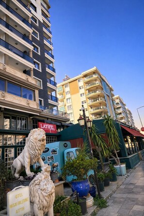 Un edificio de varios pisos, una estatua de león y un cartel que dice 'OTEL MISAFIRLIRENE AITTIR'.