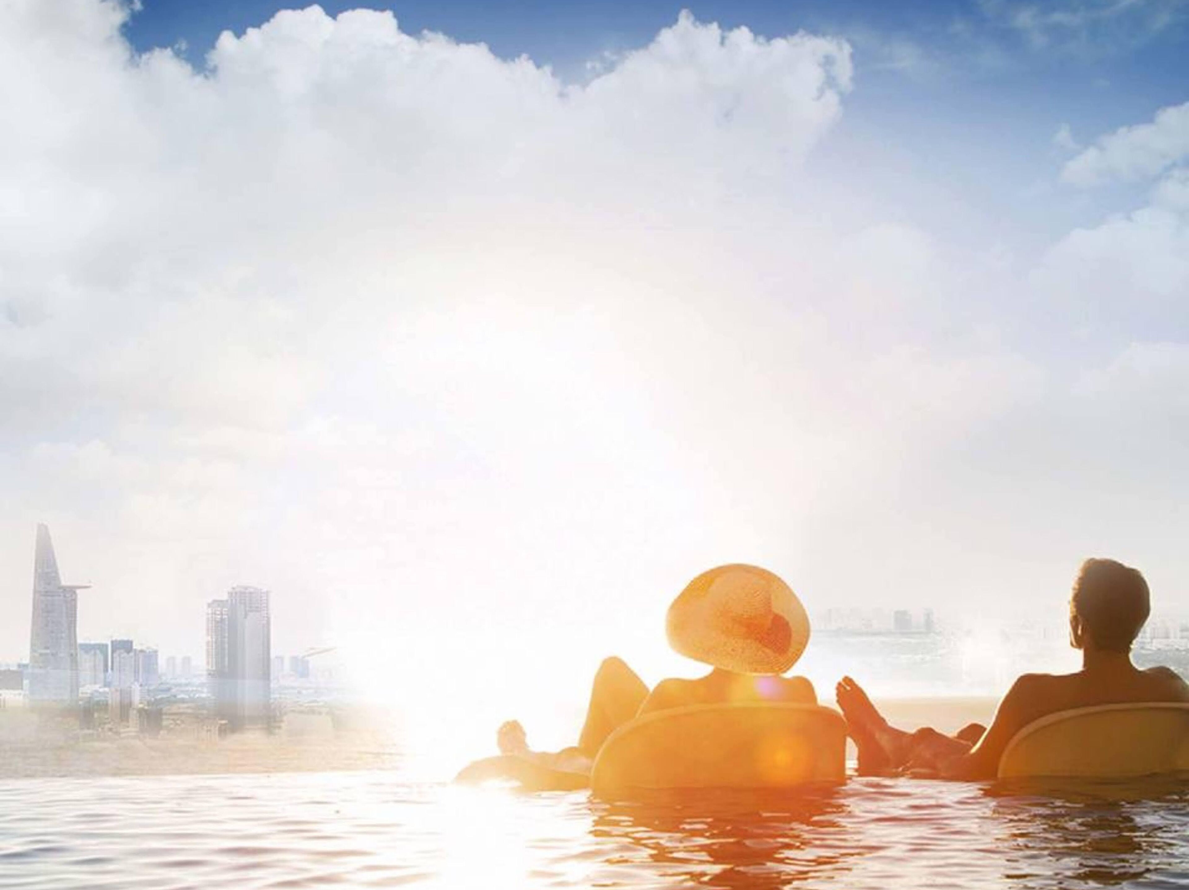 Two people relaxing in a hot tub with a cityscape in the background.