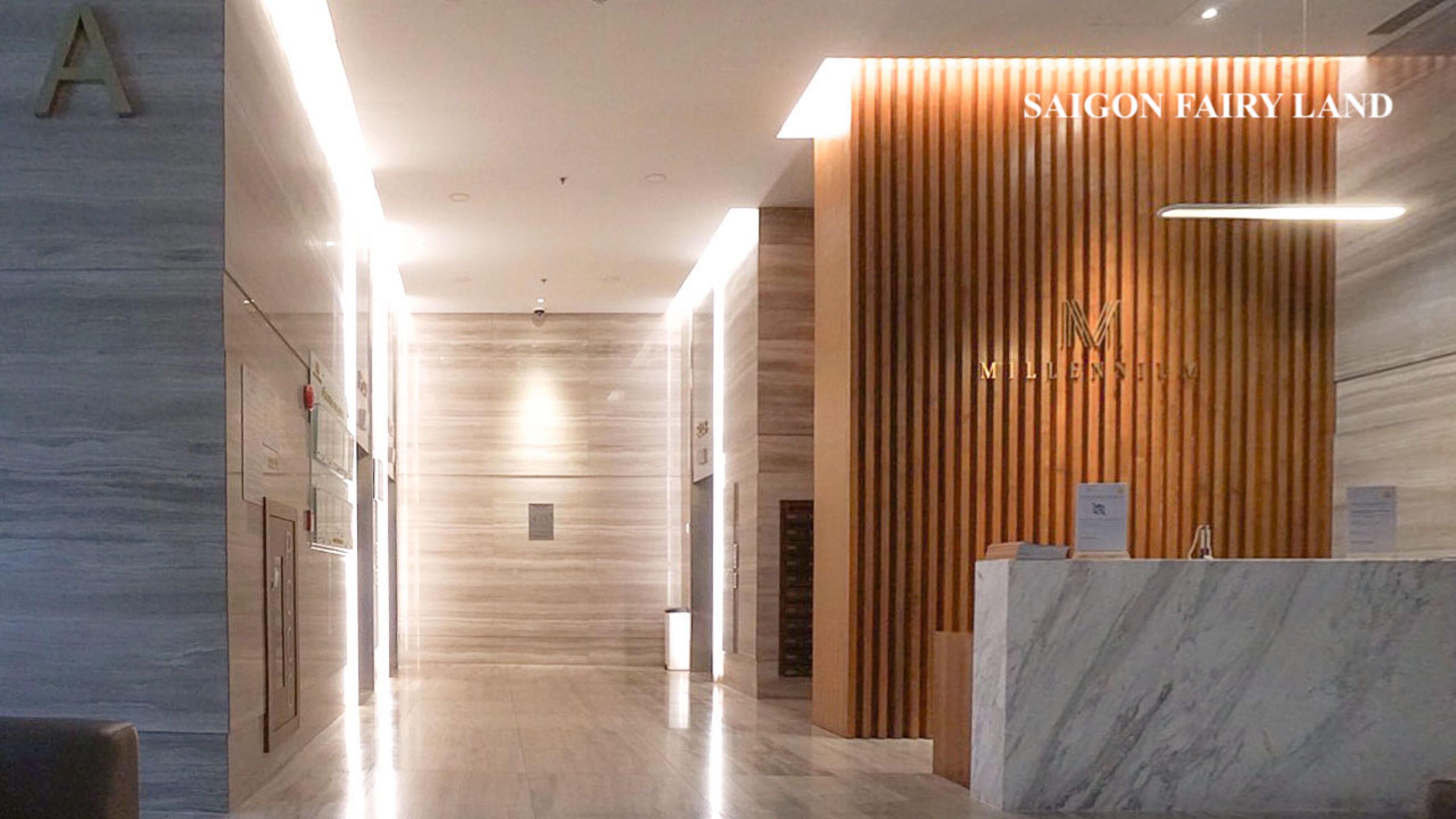 A modern hotel lobby with a reception desk labeled "SAIGON FAIRY LAND" and "MILLENNIUM."