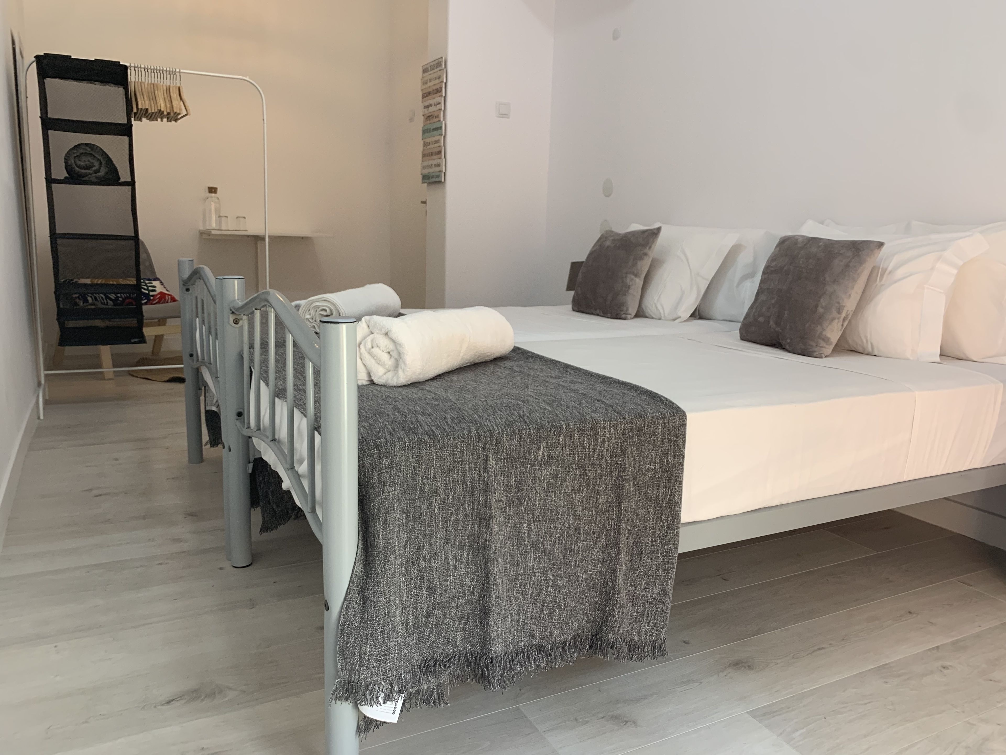 Une chambre à coucher moderne avec un lit, des oreillers, une table de chevet et une armoire.