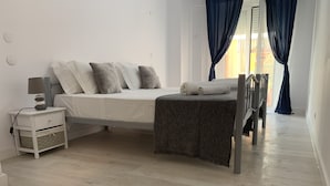Ein modernes Schlafzimmer mit Bett, Nachttisch und einem Fenster mit Vorhängen.