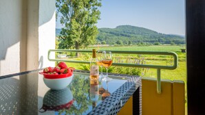 A table with a bottle of rosé wine, two glasses, and a bowl of strawberries. - Hirschenstube Gästehaus Gehri (Waldkirch)