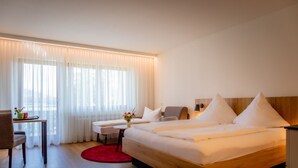 A modern hotel room with a large bed, a desk, and a chair. - Hirschenstube Gästehaus Gehri (Waldkirch)