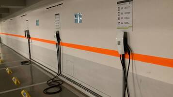 A row of electric vehicle charging stations in a parking garage.
