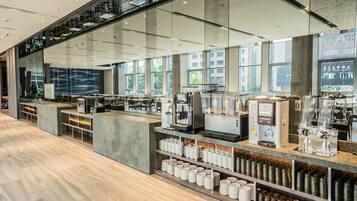 A modern coffee shop with a long counter, espresso machines, and a variety of coffee cups and containers.