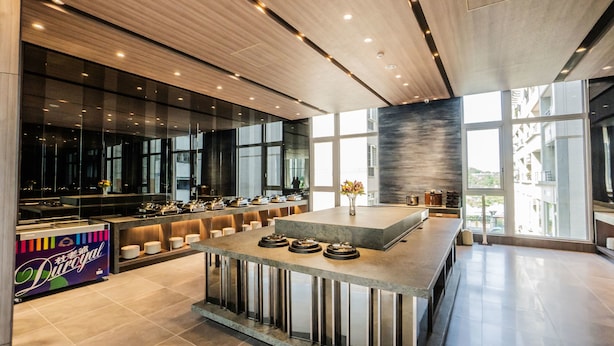 A modern hotel lobby with a central reception desk, large windows, and a contemporary design. - Jin Shi Hu Hotel (Kaohsiung)