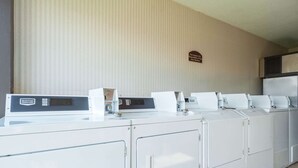 A row of Maytag front-loading washers and dryers in a hotel room.