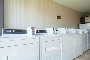 A row of Maytag front-loading washers and dryers in a hotel room.
