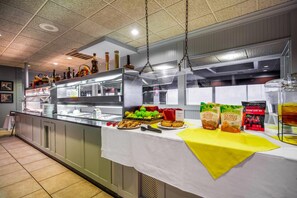 A buffet setup with various food items and condiments. - Suburban Studios I-80 Grand Island (Grand Island)