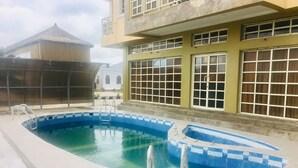 A swimming pool with a tiled deck and a ladder. - Blue Moon Beach Hotel & Resort (Lagos)