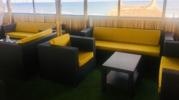 A beachside seating area with wicker furniture and a view of the ocean. - Blue Moon Beach Hotel & Resort (Lagos)