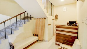 A staircase with a wooden handrail and a beige wall. - Itsy Hotels Royal Monarch (Gorakhpur)