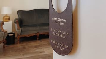 Une porte sur laquelle est apposée une pancarte indiquant : « Veuillez ranger la pièce » en anglais et en français.