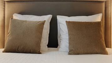 A bed with a headboard, two pillows, and a white bedspread.