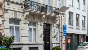 Un immeuble à plusieurs étages, de style architectural classique, caractérisé par des balcons richement décorés et de grandes fenêtres.