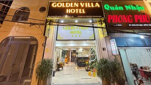 Das Golden Villa Hotel von außen, mit Empfangsbereich, Blumentöpfen und einer Treppe zum Eingang.