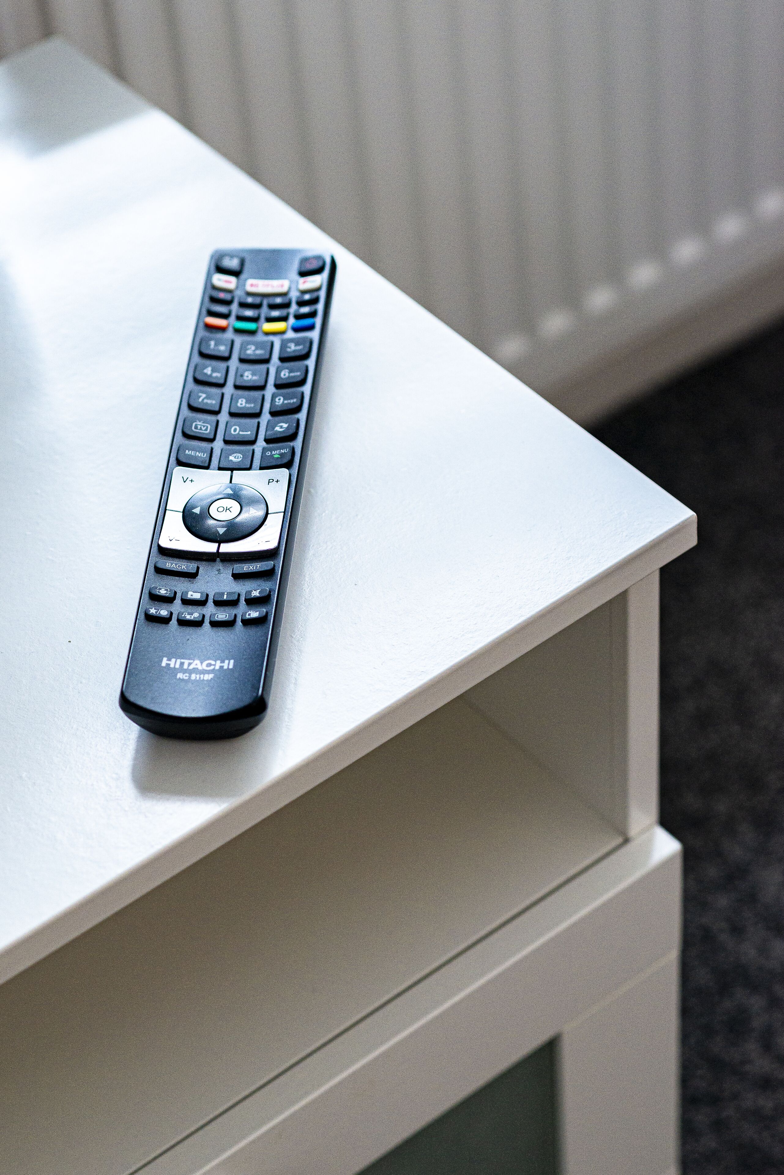 A remote control on a white table.
