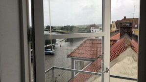 A view from a window overlooking a street with buildings and a canal. - Hotel Crone (Grenaa)